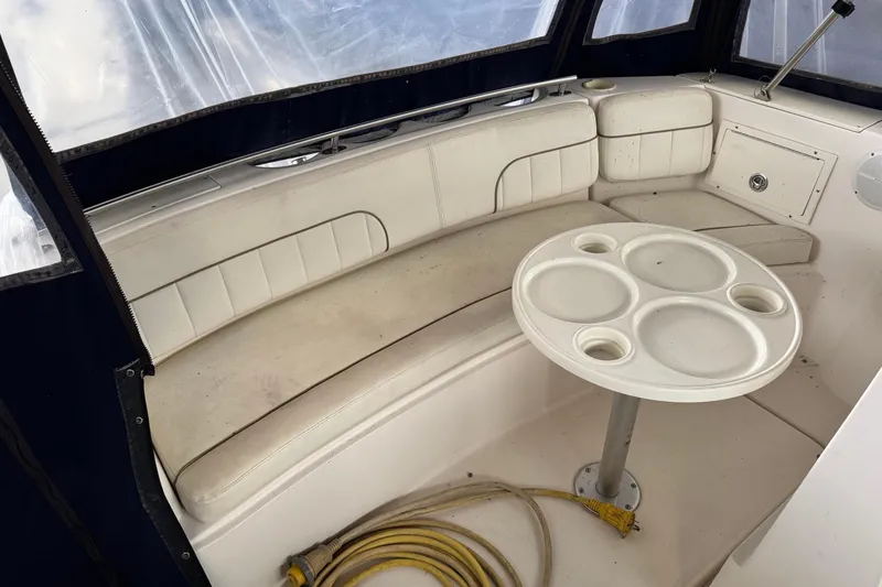 Slide: The Image of 2002 Rinker Fiesta Vee 310 boat interior with white seating and round table. - 9