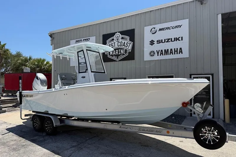 The Image of 2026 Blazer Bay Makaira 2600 boat on trailer outside marine dealership. - 1