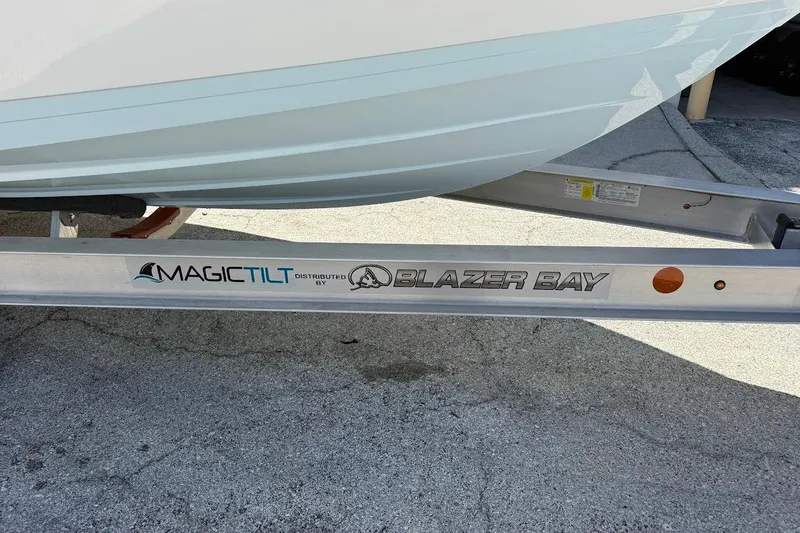 Slide: The Image of 2026 Blazer Bay Makaira 2600 boat on Magic Tilt trailer, parked on concrete. - 2