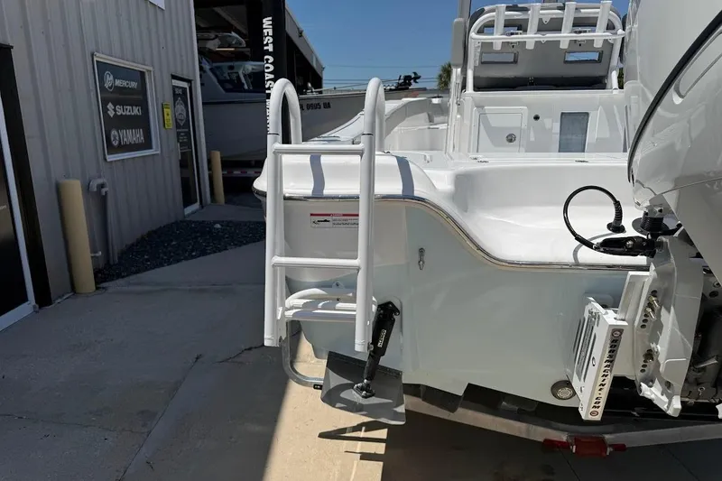 Slide: The Image of 2026 Blazer Bay Makaira 2600 boat with ladder and engine at dealership. - 8