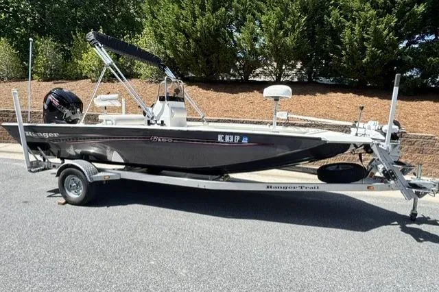 Slide: The Image of 2020 Ranger RB190 boat on trailer, parked outdoors, with trees in the background. - 1