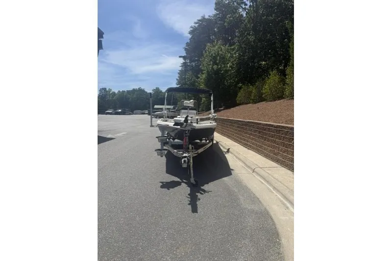 Slide: The Image of 2020 Ranger RB190 boat on trailer, parked on sunny street near trees. - 3