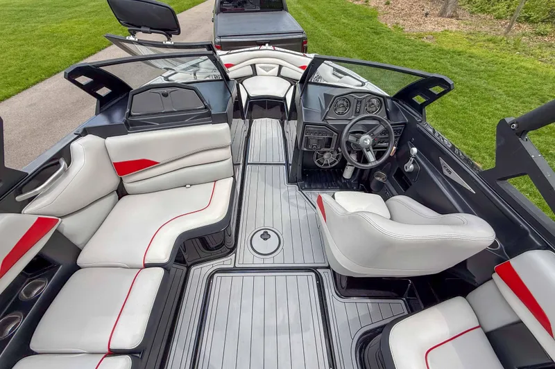 Slide: The Image of 2016 Axis A22 boat interior with white and red seating, sleek dashboard, and modern design. - 13