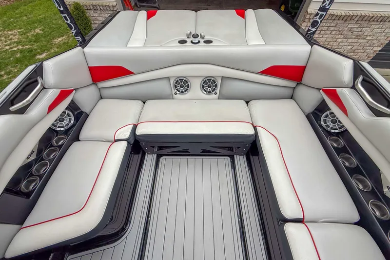 Slide: The Image of 2016 Axis A22 boat interior with gray and red seating, cup holders, and speakers. - 17