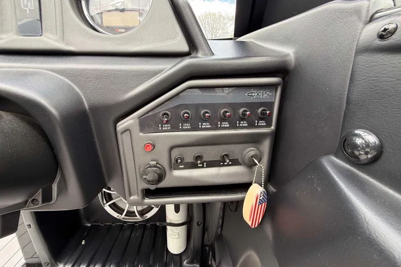 Slide: The Image of Dashboard controls of a 2016 Axis A22 boat with American flag keychain. - 21