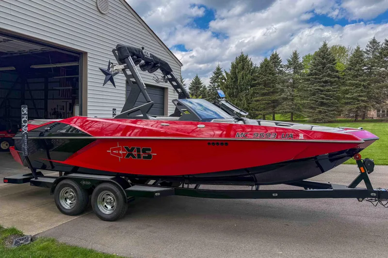 Slide: The Image of 2016 Axis A22 red boat on trailer near garage and trees. - 5