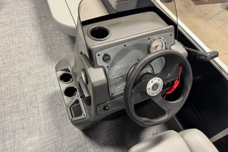 Slide: The Image of 2026 Sun Tracker Party Barge 16 DLX steering console with cup holders and controls. - 11