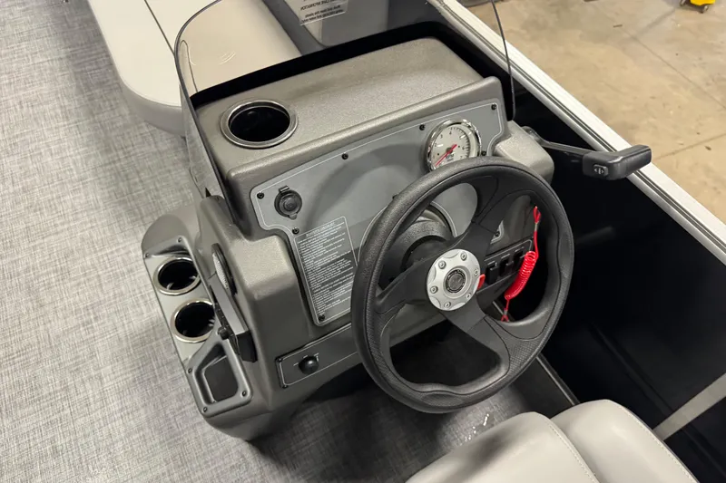 Slide: The Image of Steering console of 2026 Sun Tracker Party Barge 16 DLX with cup holders and controls. - 13
