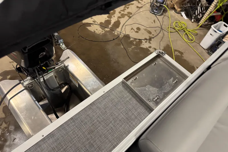 Slide: The Image of 2026 Sun Tracker Party Barge 16 DLX pontoon boat interior with motor and deck details. - 16