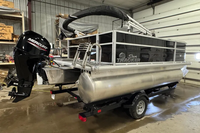 Slide: The Image of 2026 Sun Tracker Party Barge 16 DLX pontoon boat with Mercury engine in a garage. - 3