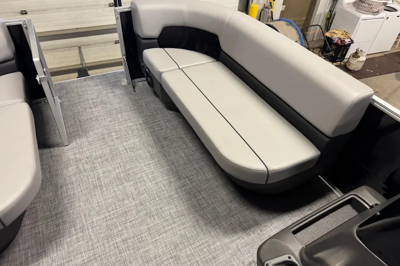 Slide: The Image of 2026 Sun Tracker Party Barge 16 DLX interior with gray seating and textured flooring. - 7
