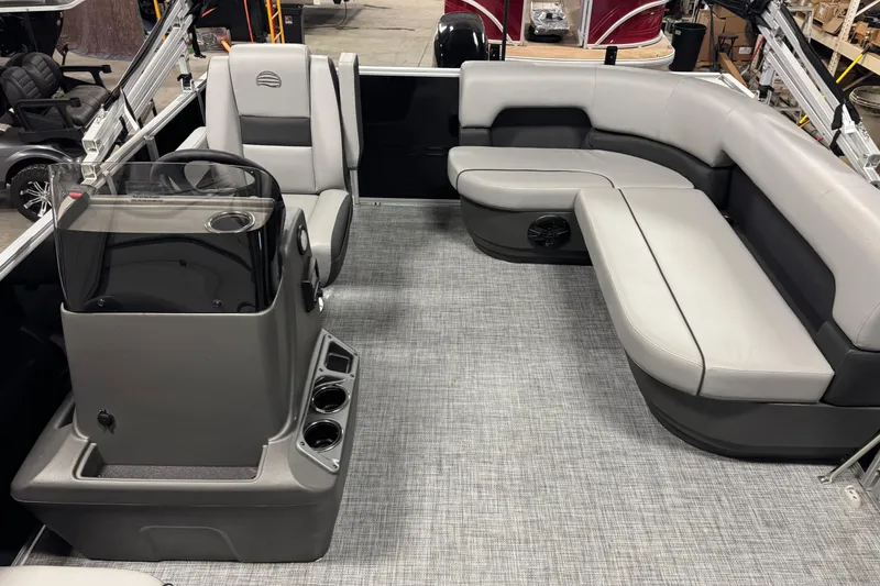Slide: The Image of 2026 Sun Tracker Party Barge 16 DLX interior with gray seating and steering console. - 9