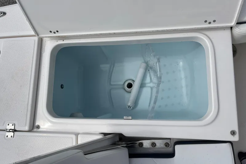 Slide: The Image of Livewell compartment on a 2024 Robalo 226 Cayman boat, open and empty. - 11