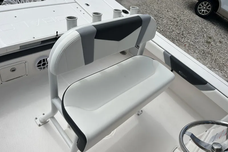 Slide: The Image of 2024 Robalo 226 Cayman boat interior with cushioned seating and rod holders. - 12