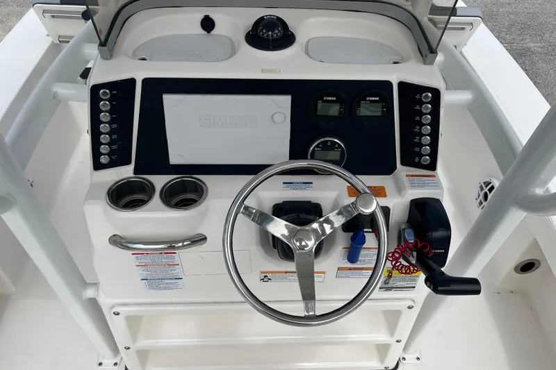 Slide: The Image of 2024 Robalo 226 Cayman boat dashboard with steering wheel and control panel. - 13