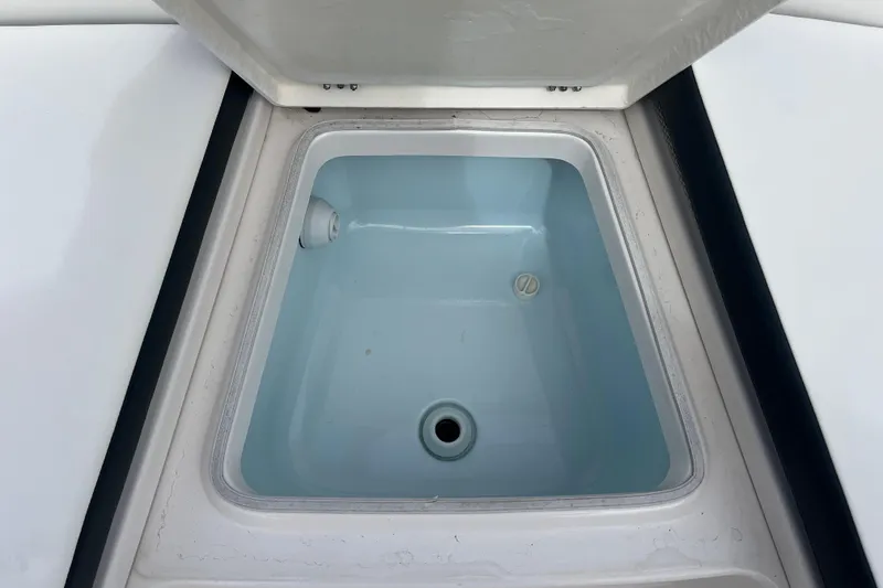 Slide: The Image of Livewell compartment on a 2024 Robalo 226 Cayman boat, open and empty. - 16