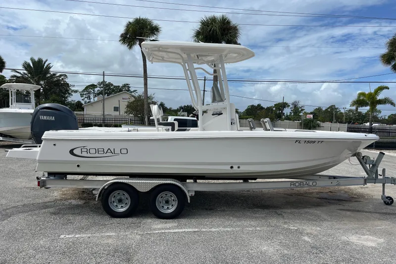 Slide: The Image of 2024 Robalo 226 Cayman boat on trailer, side view, parked outdoors. - 5