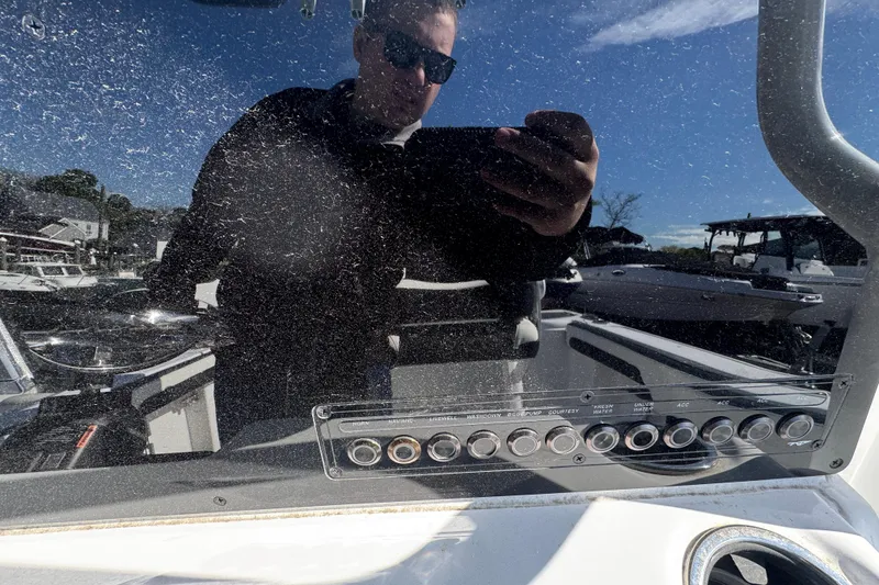 Slide: The Image of Reflection on 2026 Tidewater 220 CC Adventure boat dashboard with control panel. - 10