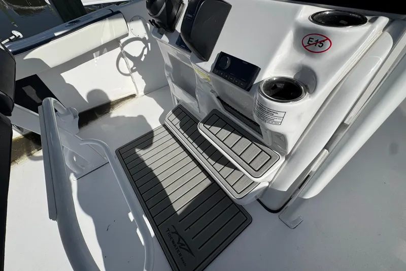 Slide: The Image of 2026 Tidewater 220 CC Adventure boat cockpit with steering wheel and cup holders. - 15