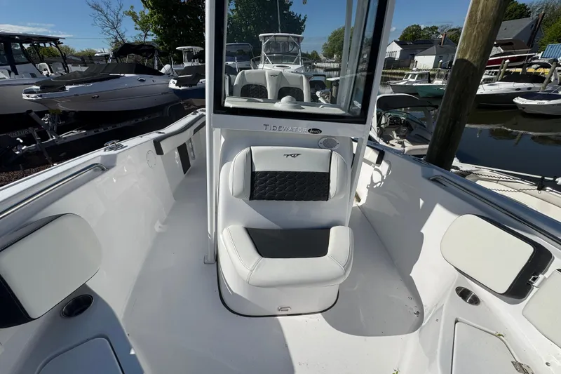 Slide: The Image of 2026 Tidewater 220 CC Adventure boat interior with seating and console, docked at marina. - 19