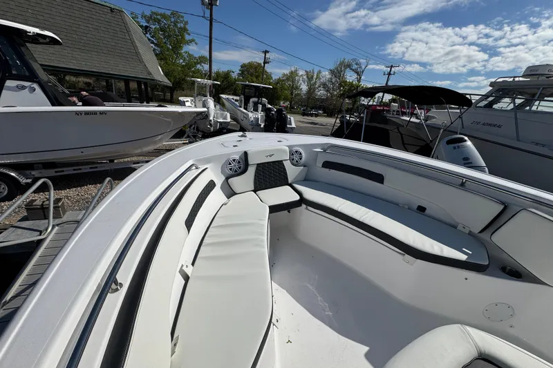 Slide: The Image of 2026 Tidewater 220 CC Adventure boat interior with white seating, docked outdoors. - 22