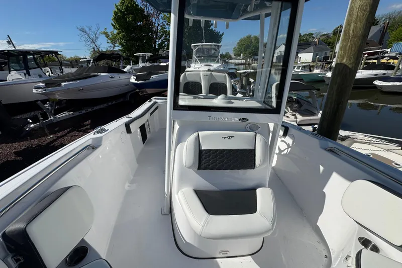 Slide: The Image of 2026 Tidewater 220 CC Adventure boat interior, featuring sleek seating and modern design at a marina. - 23