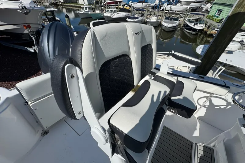 Slide: The Image of 2026 Tidewater 220 CC Adventure boat interior with stylish seating at marina. - 7