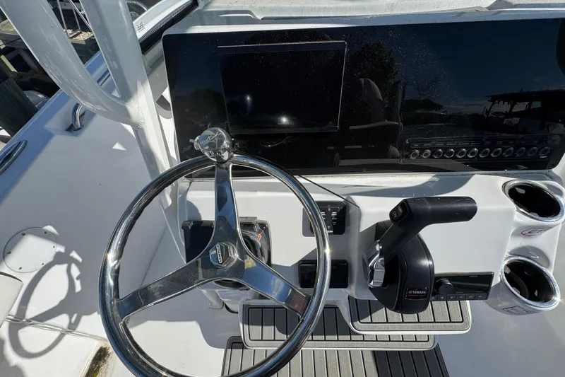 Slide: The Image of Steering console of 2026 Tidewater 220 CC Adventure boat with controls and cup holders. - 8