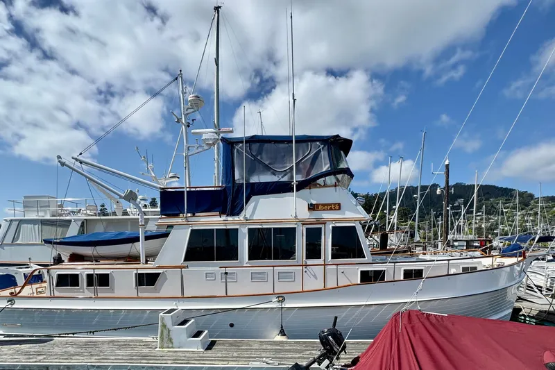 The Image of 1996 Grand Banks 46 Heritage CL yacht docked at a marina under a blue sky. - 0
