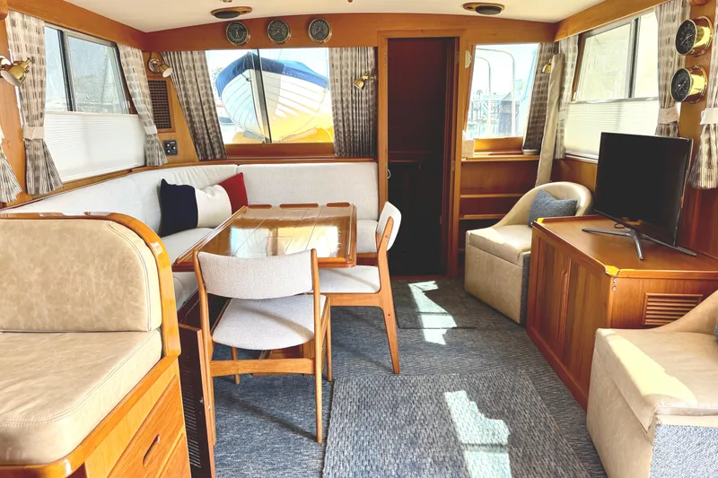 Slide: The Image of Interior of 1996 Grand Banks 46 Heritage CL yacht, featuring cozy seating and elegant wood finishes. - 14