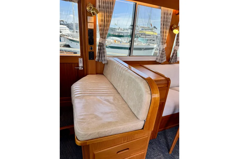 Slide: The Image of Interior of 1996 Grand Banks 46 Heritage CL yacht with cushioned seating and marina view. - 25
