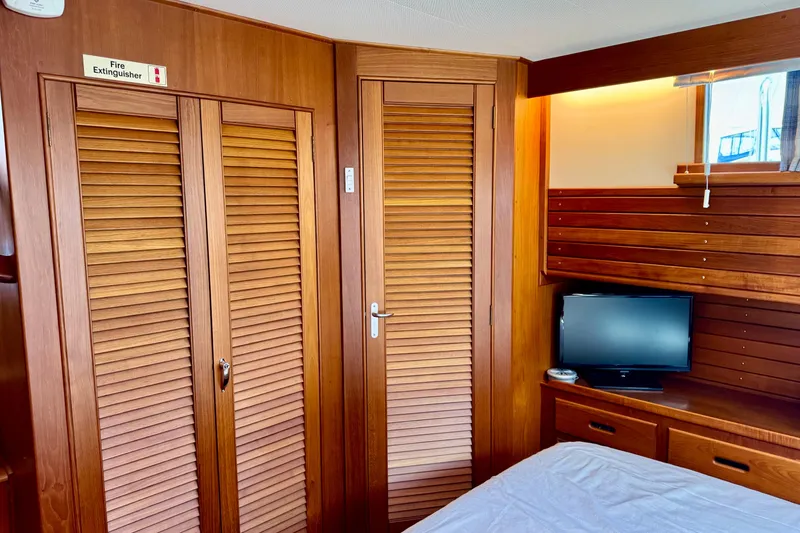 Slide: The Image of Interior of 1996 Grand Banks 46 Heritage CL with wooden cabinetry and small TV. - 28
