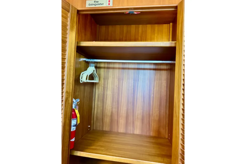 Slide: The Image of Wooden closet with hangers and fire extinguisher on a 1996 Grand Banks 46 Heritage CL. - 32