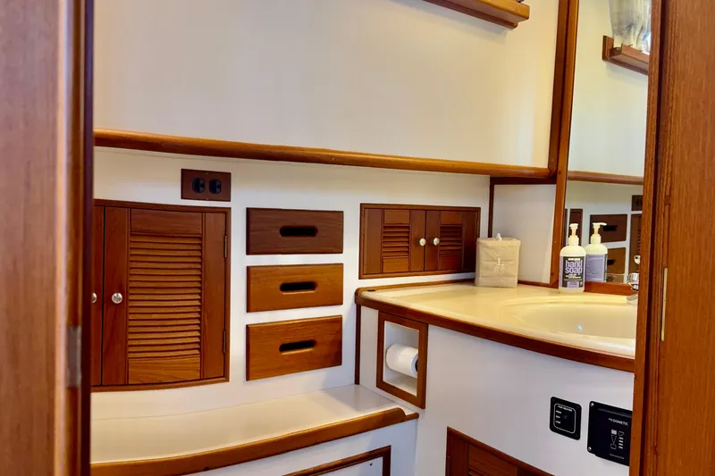 Slide: The Image of Bathroom interior of 1996 Grand Banks 46 Heritage CL yacht, featuring wooden cabinetry and sink. - 36