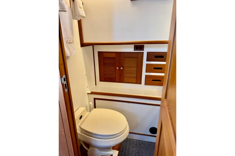 Slide: The Image of Bathroom interior of 1996 Grand Banks 46 Heritage CL yacht, featuring wooden cabinetry and toilet. - 37