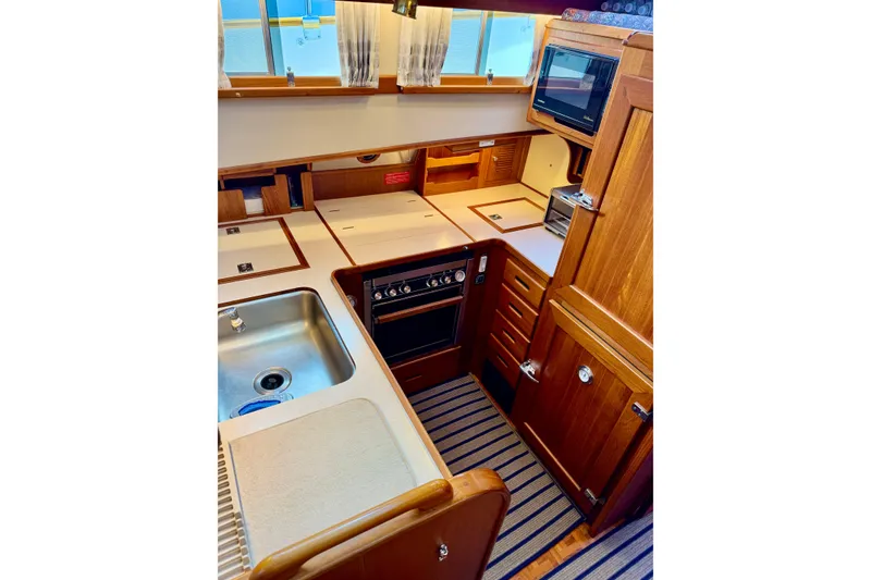 Slide: The Image of 1996 Grand Banks 46 Heritage CL yacht kitchen with wood cabinetry, stainless steel sink, and appliances. - 39