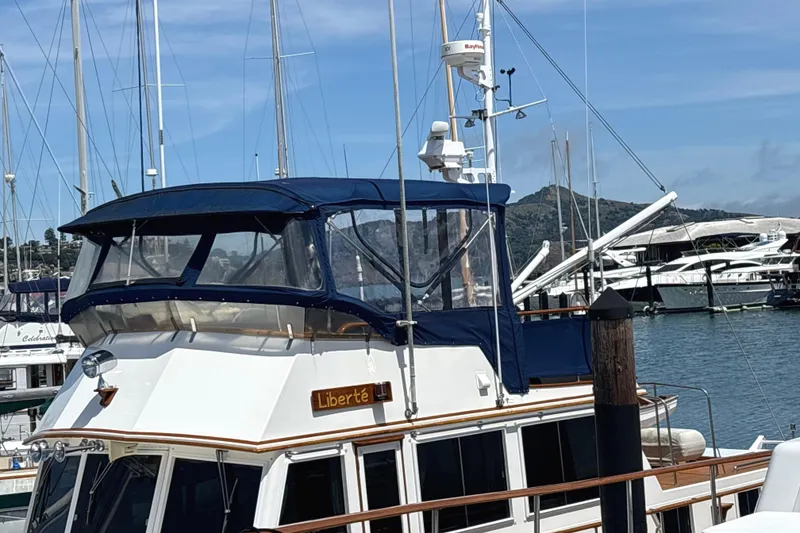 Slide: The Image of 1996 Grand Banks 46 Heritage CL yacht docked in a marina, featuring a blue canopy. With New Strata Glass - 4