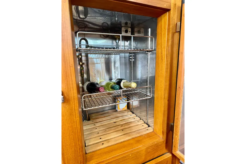 Slide: The Image of Wooden cabinet with wine bottles inside a Grand Banks 46 Heritage CL, 1996 model. - 43