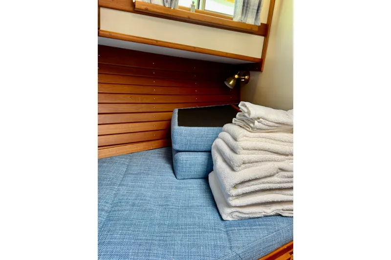 Slide: The Image of Cozy cabin interior of 1996 Grand Banks 46 Heritage CL with blue cushions and folded towels. - 51