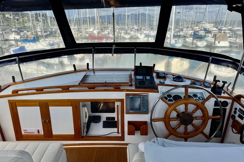 Slide: The Image of Helm of 1996 Grand Banks 46 Heritage CL yacht with wooden wheel and navigation instruments. - 54