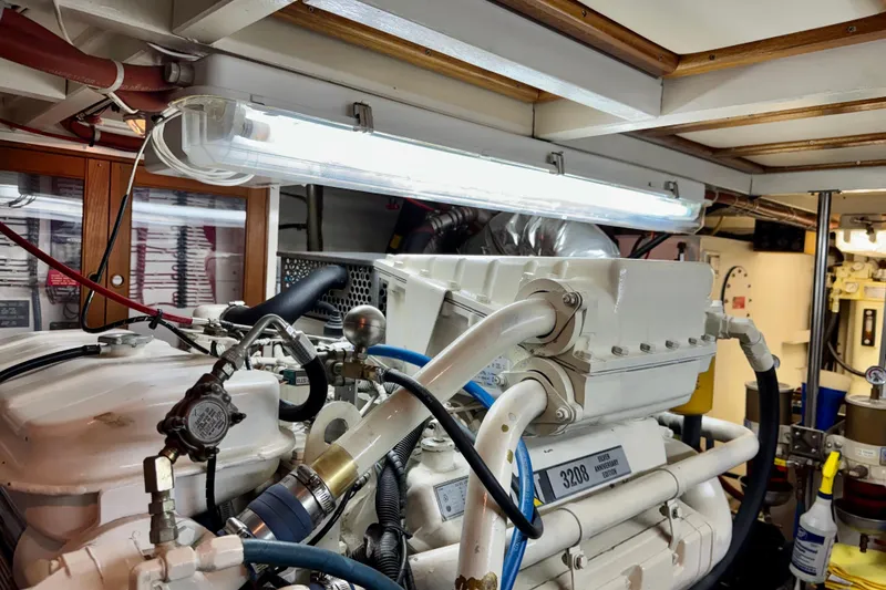 Slide: The Image of Engine room of a 1996 Grand Banks 46 Heritage CL yacht, featuring mechanical components and lighting. - 63
