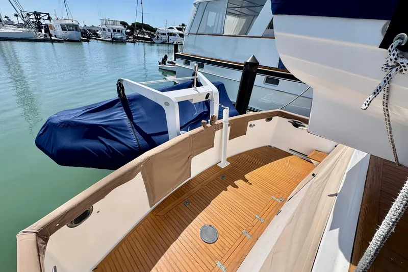 Slide: The Image of 1996 Grand Banks 46 Heritage CL yacht with teak deck and covered dinghy at marina. - 70