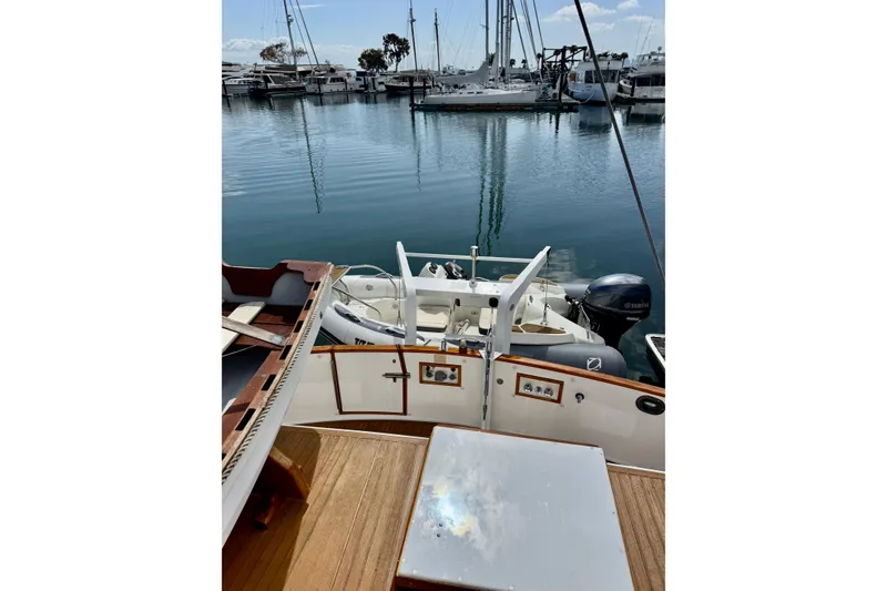 Slide: The Image of 1996 Grand Banks 46 Heritage CL yacht docked at marina with dinghy and Yamaha motor. - 77