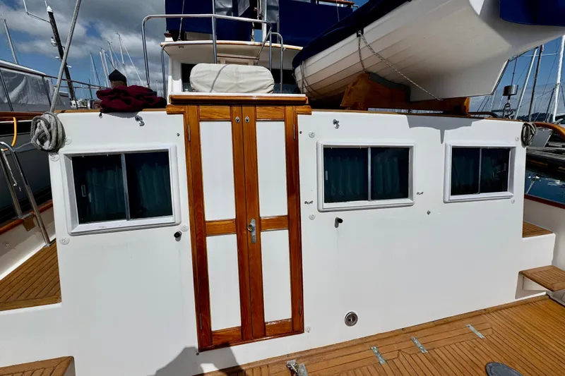 Slide: The Image of 1996 Grand Banks 46 Heritage CL yacht with wooden doors and windows, docked at a marina. - 8