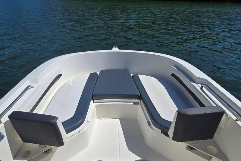 Slide: The Image of 2023 Bayliner Trophy T22CC boat interior with cushioned seating on calm water. - 10