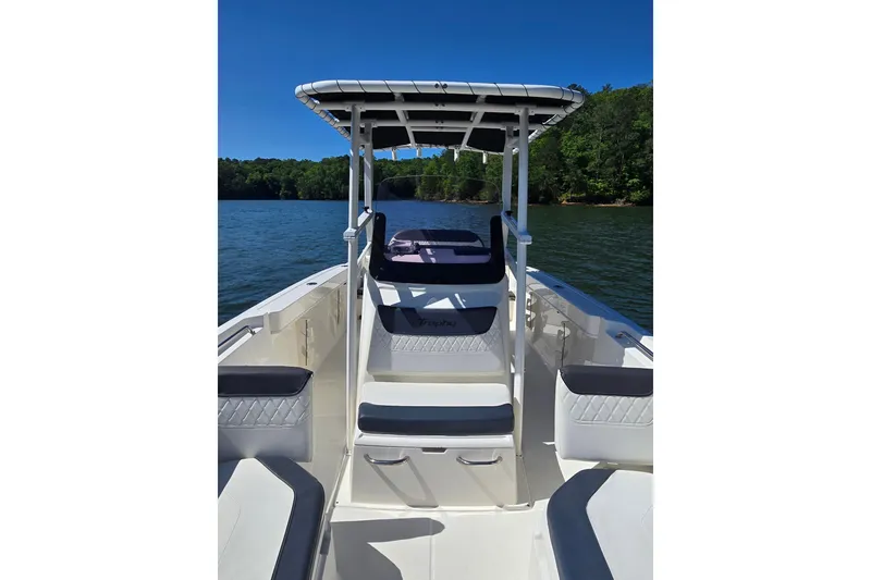 Slide: The Image of 2023 Bayliner Trophy T22CC boat on a lake, featuring sleek seating and canopy. - 13