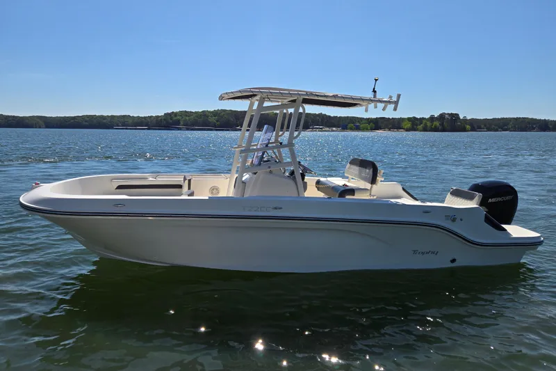 Slide: The Image of 2023 Bayliner Trophy T22CC boat on a sunny lake, showcasing sleek design and powerful engine. - 4