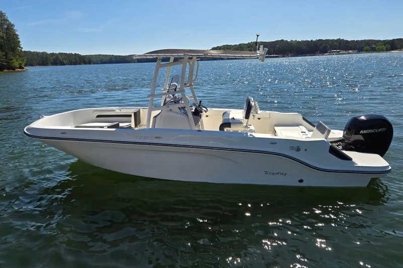 Slide: The Image of 2023 Bayliner Trophy T22CC boat on a sunny lake, featuring a Mercury engine. - 5