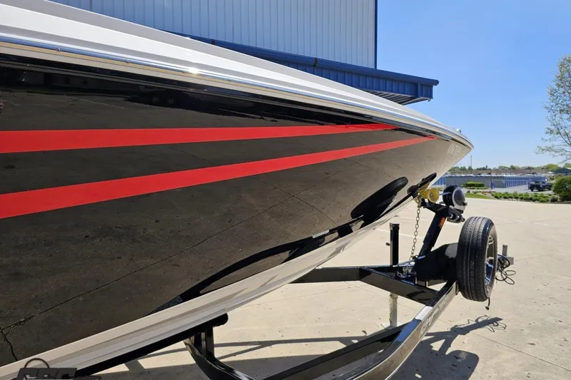 Slide: The Image of 2019 Baja 27 Outlaw boat with red stripes on a trailer, parked outdoors. - 10