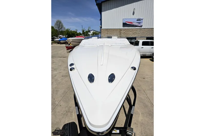 Slide: The Image of 2019 Baja 27 Outlaw boat on trailer, parked outdoors near a building. - 13